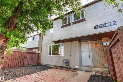 Brick paver patio with dark aggregate accents, leading to the entry - #9 14230 80 St Nw, Edmonton, AB - Outdoor With Exterior