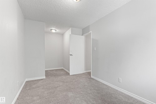 Neutral-toned room featuring light gray walls, plush gray carpeting, and a white ceiling with recessed lighting - #9 14230 80 St Nw, Edmonton, AB - Indoor Photo Showing Other Room