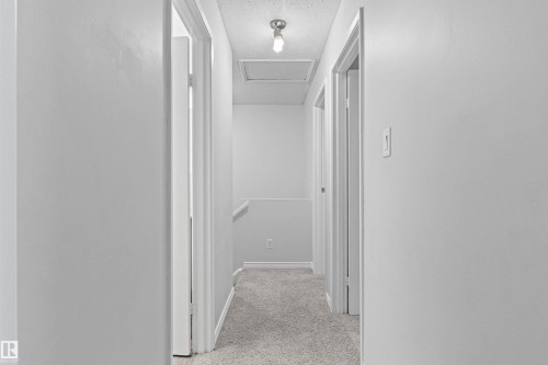 Bright hallway with clean white walls, recessed ceiling lighting, and neutral-toned carpet flooring - #9 14230 80 St Nw, Edmonton, AB - Indoor Photo Showing Other Room