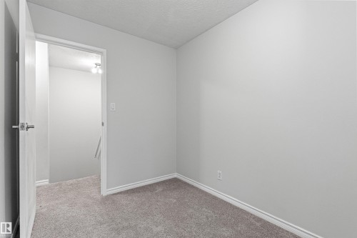 Gray carpeting with white baseboards, light-toned walls, and a white ceiling - #9 14230 80 St Nw, Edmonton, AB - Indoor Photo Showing Other Room