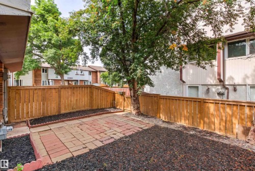 Spacious backyard retreat featuring a low-maintenance gravel landscape, brick-paver patio, and sturdy wood-finish privacy fencing - #9 14230 80 St Nw, Edmonton, AB - Outdoor