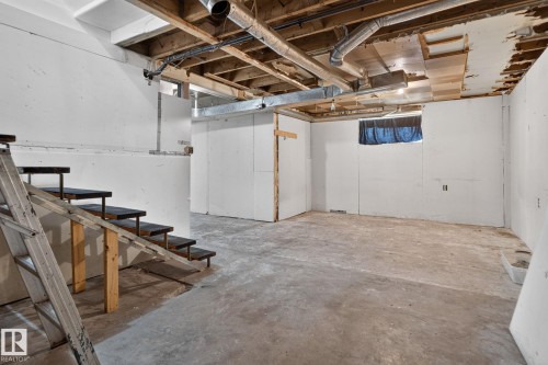 Unfinished basement featuring exposed ceiling joists, concrete flooring, and a window - 9921 109 Street, Fort Saskatchewan, AB - Indoor Photo Showing Basement