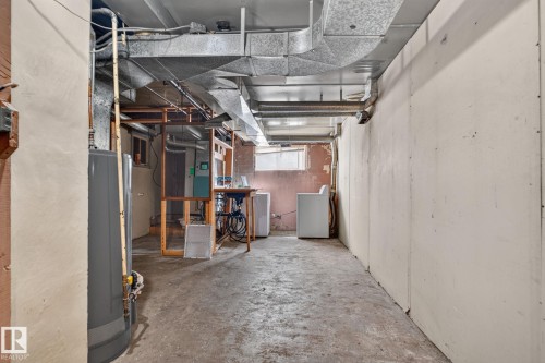 Unfinished basement with concrete flooring, exposed ductwork, and a utility sink - 9921 109 Street, Fort Saskatchewan, AB - Indoor Photo Showing Basement