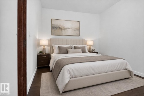 Dark wood-finish flooring with white baseboards, and a wooden door frame - 9921 109 Street, Fort Saskatchewan, AB - Indoor Photo Showing Bedroom