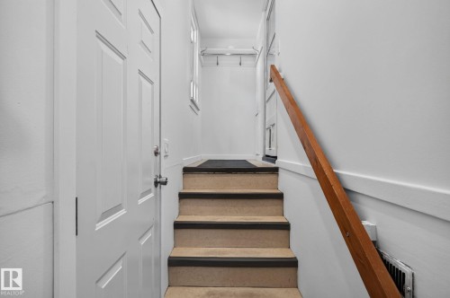 Staircase featuring wood handrail and light-colored treads with dark risers - 9921 109 Street, Fort Saskatchewan, AB - Indoor Photo Showing Other Room