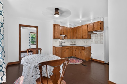 Kitchen featuring wood cabinetry, white countertops, and a tile backsplash - 9921 109 Street, Fort Saskatchewan, AB - Indoor