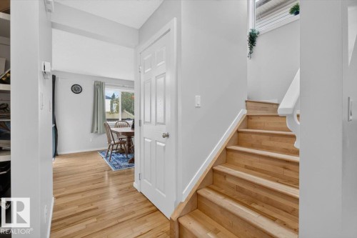 Hardwood flooring, painted interior walls, white trim, wood staircase with white railing, and a window with natural light - 722 88A Street Sw, Edmonton, AB - Indoor Photo Showing Other Room