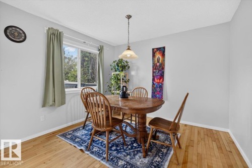 Hardwood flooring, painted walls, window with natural light, and ceiling-mounted light fixture - 722 88A Street Sw, Edmonton, AB - Indoor Photo Showing Dining Room