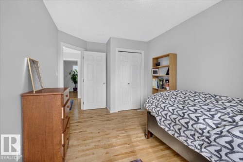 Light wood-finish flooring with white trim - 722 88A Street Sw, Edmonton, AB - Indoor Photo Showing Bedroom