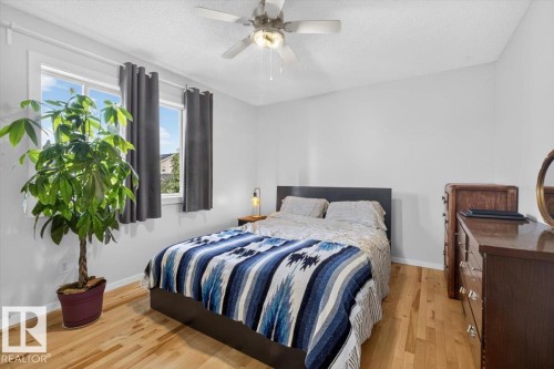 Hardwood flooring, two windows, and a ceiling fan - 722 88A Street Sw, Edmonton, AB - Indoor Photo Showing Bedroom
