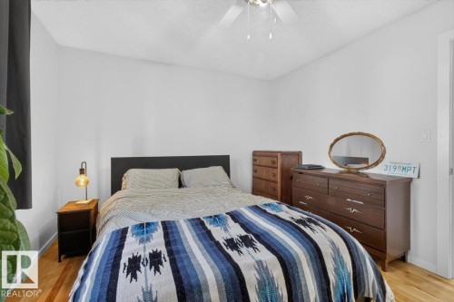Hardwood flooring, white painted walls, and a ceiling fan with integrated lighting - 722 88A Street Sw, Edmonton, AB - Indoor Photo Showing Bedroom