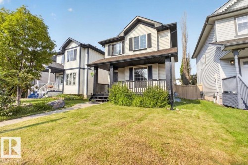Spacious two-story home with a substantial manicured lawn, mature landscaping, and a covered front porch - 722 88A Street Sw, Edmonton, AB - Outdoor With Deck Patio Veranda