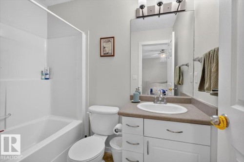 White vanity with a laminate countertop and an integrated sink - 722 88A Street Sw, Edmonton, AB - Indoor Photo Showing Bathroom