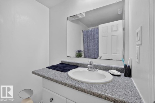 Vanity with a speckled countertop, a white oval sink, and a chrome faucet - 722 88A Street Sw, Edmonton, AB - Indoor Photo Showing Bathroom