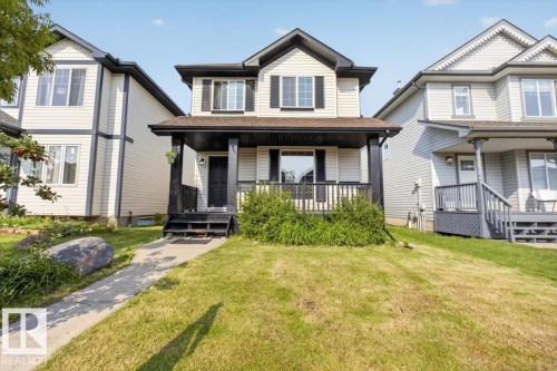Two-story home featuring a welcoming front facade with dark trim detailing, gable roofline, and covered front porch with railing - 722 88A Street Sw, Edmonton, AB - Outdoor With Deck Patio Veranda With Facade