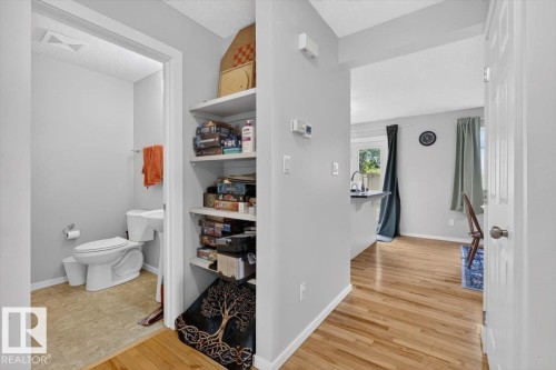 Hallway featuring built-in shelving, wood-finish flooring, and light gray wall paint - 722 88A Street Sw, Edmonton, AB - Indoor