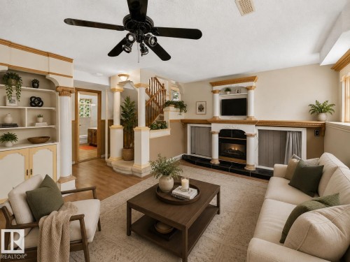 Built-in shelving, decorative columns, wall-mounted fireplace with black hearth, wood-finish flooring, and ceiling fan with integrated lighting - 6348 34A Avenue Nw, Edmonton, AB - Indoor Photo Showing Living Room With Fireplace