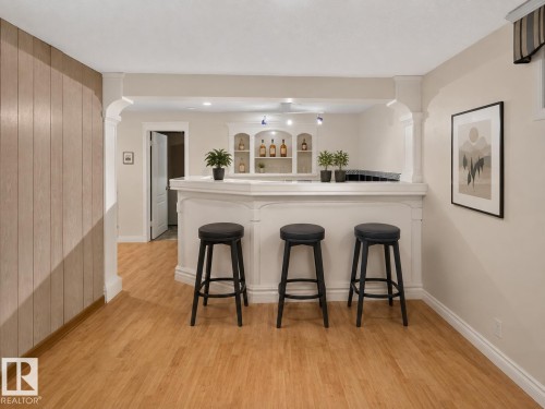 Built-in bar with arched details, recessed shelving, and integrated lighting - 6348 34A Avenue Nw, Edmonton, AB - Indoor