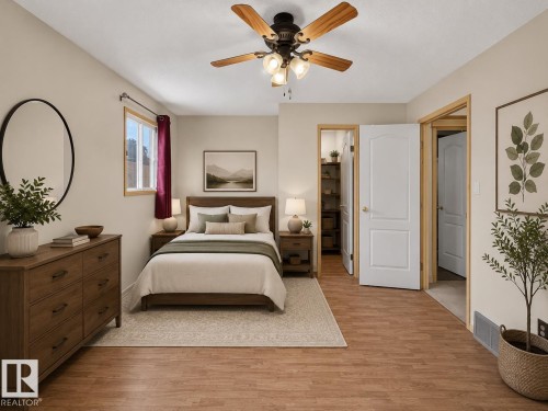 Wood-finish flooring, ceiling fan with light fixture, window with wood trim, and two-panel interior doors - 6348 34A Avenue Nw, Edmonton, AB - Indoor Photo Showing Bedroom