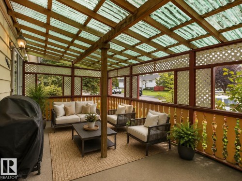 Covered patio featuring a translucent panel roof, wood support beams, lattice privacy screens, and a concrete surface - 6348 34A Avenue Nw, Edmonton, AB - Indoor Photo Showing Other Room