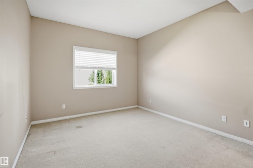 Light-filled room featuring neutral wall paint, white trim, and carpet flooring - #95 3040 Spence Wd Sw, Edmonton, AB - Indoor Photo Showing Other Room
