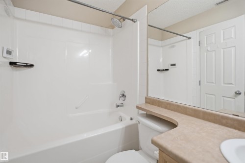 Bathroom featuring a white bathtub and shower combination with chrome fixtures - #95 3040 Spence Wd Sw, Edmonton, AB - Indoor Photo Showing Bathroom