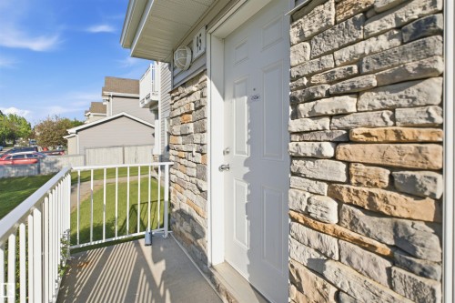 Entryway featuring a white paneled door and multi-toned stone veneer siding - #95 3040 Spence Wd Sw, Edmonton, AB - Outdoor