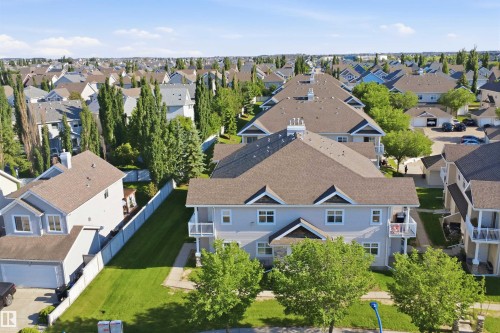 Light blue multi-story building featuring a brown shingle roof, multiple windows, and two balconies with white railings - #95 3040 Spence Wd Sw, Edmonton, AB - Outdoor With View
