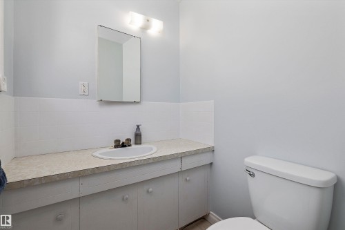 Clean and functional bathroom featuring a floating vanity with light wood-finish countertop, round vessel sink, and ample storage - 3511 73 Street Nw, Edmonton, AB 