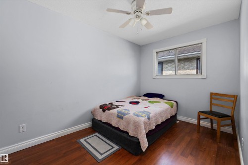 Wood-finish flooring, light gray walls, white window trim, and a ceiling fan with integrated lighting - 3511 73 Street Nw, Edmonton, AB 