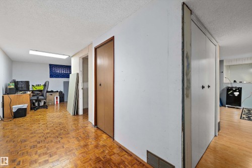 Spacious open-plan layout with wood-finish parquet flooring throughout, multiple entry doors providing flexible access, and abundant overhead lighting - 3511 73 Street Nw, Edmonton, AB 