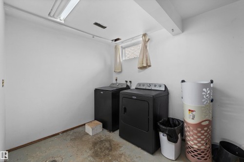 Laundry area featuring a washer and dryer, exposed ceiling beam, fluorescent lighting, and a small window - 3511 73 Street Nw, Edmonton, AB 