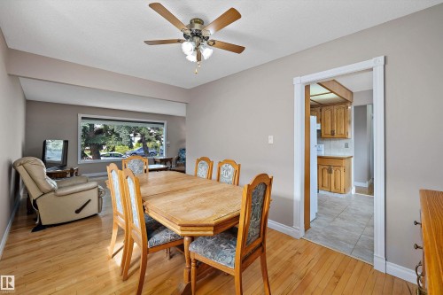 Dining area with wood-finish flooring, oval wood dining table, and four upholstered chairs - 3511 73 Street Nw, Edmonton, AB 