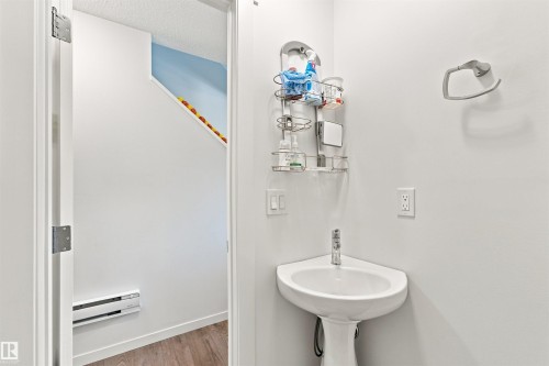Pedestal corner sink with wall-mounted faucet and neutral wall finishes - 1172 Aster Boulevard Nw Nw, Edmonton, AB - Indoor Photo Showing Bathroom