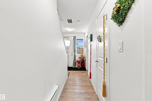 Entryway with wood-finish flooring, white walls, and a white door with a clear glass insert - 1172 Aster Boulevard Nw Nw, Edmonton, AB - Indoor Photo Showing Other Room
