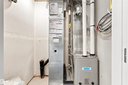 Mechanical room featuring high-efficiency HVAC system with dual units, water filtration setup, and organized utility infrastructure - 1172 Aster Boulevard Nw Nw, Edmonton, AB - Indoor Photo Showing Basement