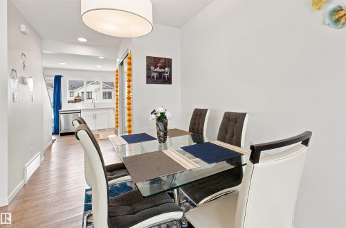 Dining area with wood-finish flooring and a contemporary drum pendant light - 1172 Aster Boulevard Nw Nw, Edmonton, AB - Indoor Photo Showing Dining Room