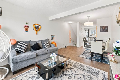 Open-concept living and dining area featuring wood-finish flooring, recessed lighting, and a contemporary drum pendant light - 1172 Aster Boulevard Nw Nw, Edmonton, AB - Indoor Photo Showing Living Room