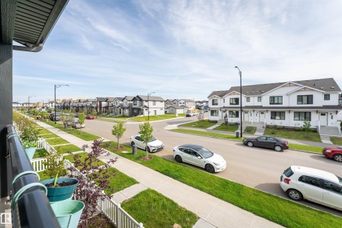 White picket fence bordering a paved sidewalk with streetlights - 1172 Aster Boulevard Nw Nw, Edmonton, AB - Outdoor