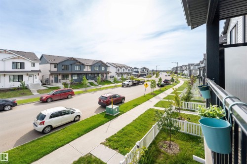 Streetscape featuring a consistent sidewalk, manicured green spaces, and a variety of residential architectural styles - 1172 Aster Boulevard Nw Nw, Edmonton, AB - Outdoor