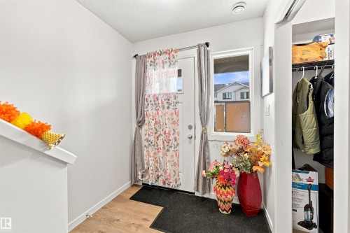 Entryway featuring wood-finish flooring, a white door with a window, and a built-in closet with shelving and hanging storage - 1172 Aster Boulevard Nw Nw, Edmonton, AB - Indoor Photo Showing Other Room