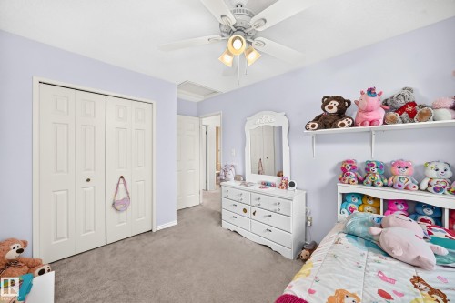 Recessed paneled bi-fold closet doors, wall-to-wall carpeting, and a ceiling fan with integrated lighting - 2404 37 Street Nw, Edmonton, AB - Indoor Photo Showing Bedroom