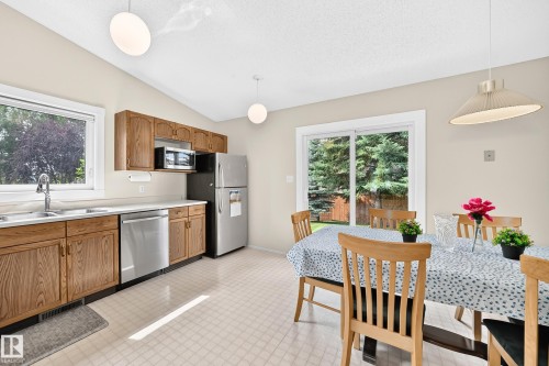 Kitchen featuring wood cabinetry, stainless steel appliances, and a double basin sink - 2404 37 Street Nw, Edmonton, AB - Indoor Photo Showing Kitchen With Double Sink