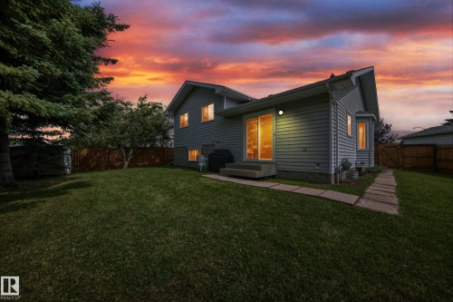 Expansive backyard with a manicured lawn, wood fencing, and mature trees - 2404 37 Street Nw, Edmonton, AB - Outdoor