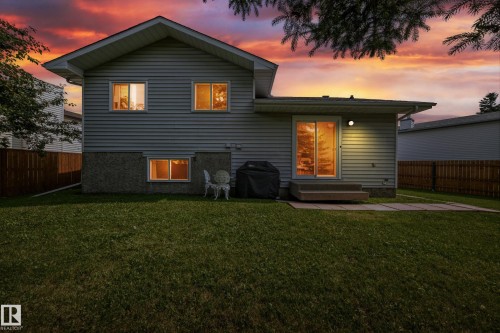 Expansive backyard featuring a manicured lawn, partial wood privacy fencing, and a concrete patio - 2404 37 Street Nw, Edmonton, AB - Outdoor