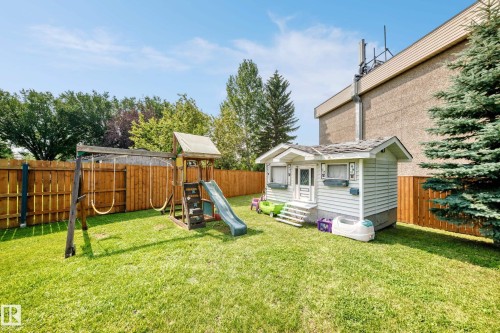 Expansive backyard with a manicured lawn, full wood fencing, and mature trees - 2404 37 Street Nw, Edmonton, AB - Outdoor
