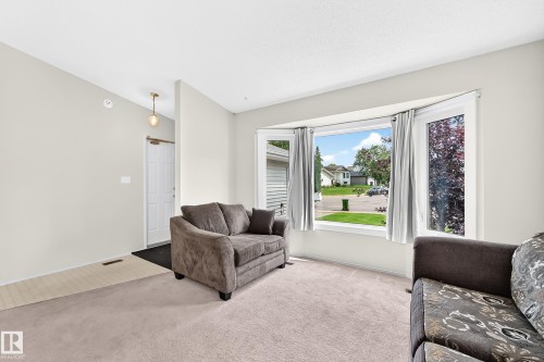 Bay window with white trim, light-colored walls, and a suspended ceiling light fixture - 2404 37 Street Nw, Edmonton, AB - Indoor Photo Showing Living Room