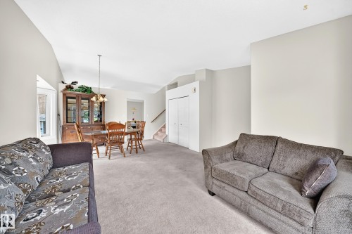 Open-concept living space featuring vaulted ceilings, neutral wall tones, and light-toned carpeting - 2404 37 Street Nw, Edmonton, AB - Indoor Photo Showing Living Room