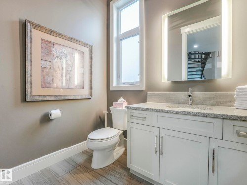 White vanity with a stone countertop, under-mount sink, and contemporary faucet - 8927 120 Street Nw, Edmonton, AB - Indoor Photo Showing Bathroom