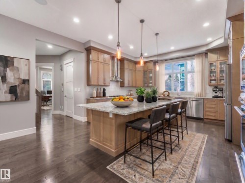 Gourmet kitchen with wood-finish flooring, recessed lighting, and a large island featuring pendant lighting - 8927 120 Street Nw, Edmonton, AB - Indoor